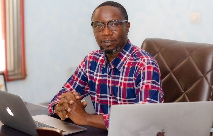 Image extérieure : Alfred Ntumba devant son bureau